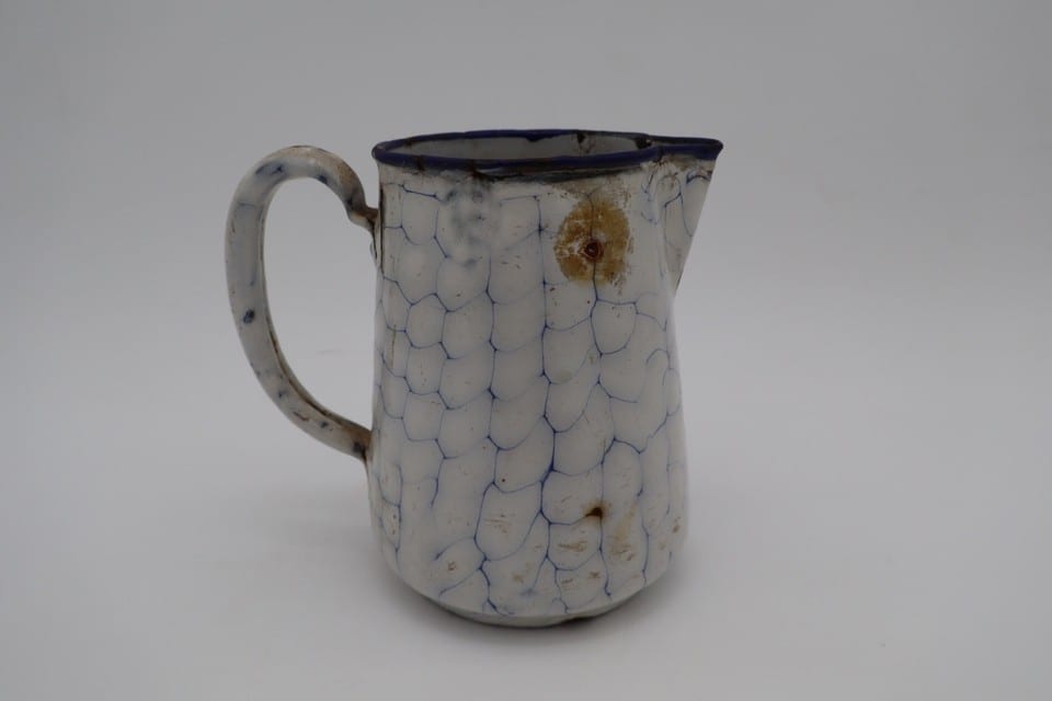 Ancien broc à eau en tôle émaillée blanche décor craquelé bleu